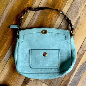 A beautiful robins egg blue pebbled leather Coach purse with satin green lining.